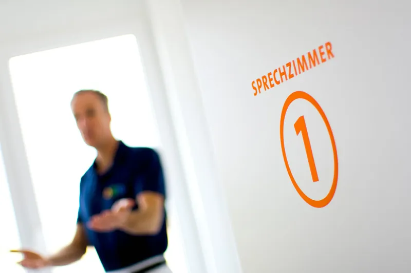 Arzt an der Tür zu Sprechzimmer 1